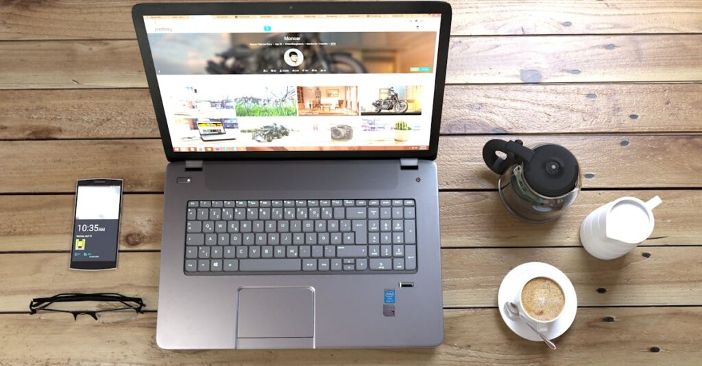 Top view of a laptop, smartphone, coffee, and glasses on a wooden desk.